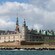 Kronborg Castle facing the ocean with a Danish flag flying out front